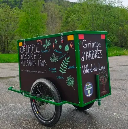 Photo de la remorque où il est écrit « Grimpe d’arbres »